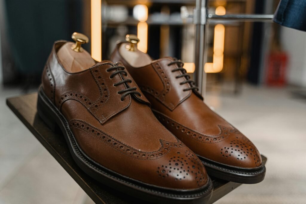naprawa-butów-miasteczko-śląskie Classic brown leather brogue shoes with detailed perforations on a stylish display.